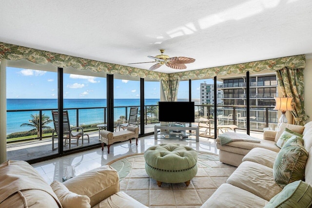 tiled living room with ceiling fan and a textured ceiling