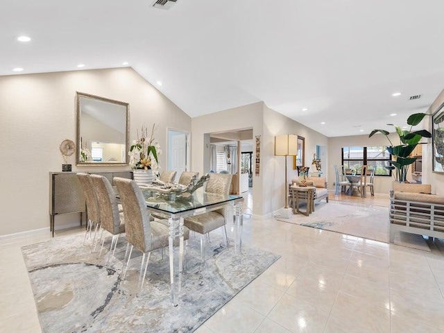 tiled dining area featuring vaulted ceiling