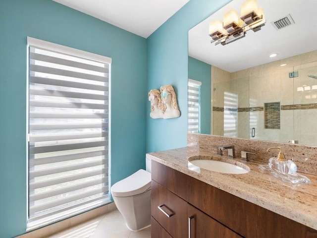 bathroom featuring toilet, vanity, tile patterned floors, and a shower with door