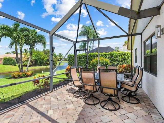 view of patio / terrace with glass enclosure and a water view