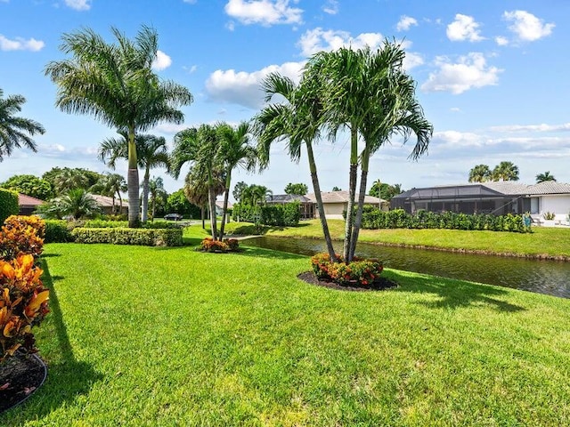 view of yard with a lanai and a water view