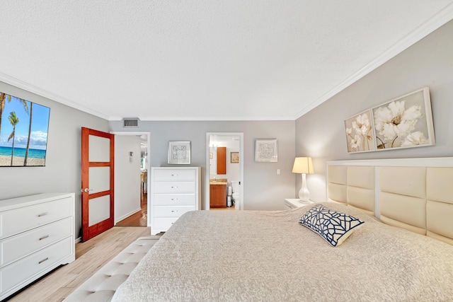 bedroom featuring ensuite bathroom, crown molding, and light hardwood / wood-style floors