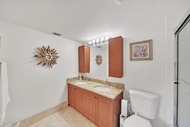 bathroom featuring tile patterned flooring, vanity, toilet, and walk in shower