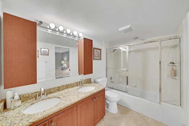 full bathroom featuring tile patterned floors, toilet, combined bath / shower with glass door, and vanity