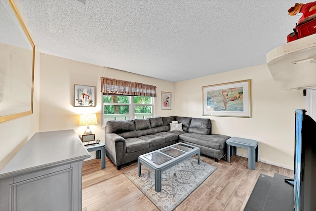 living room featuring light hardwood / wood-style flooring and a textured ceiling