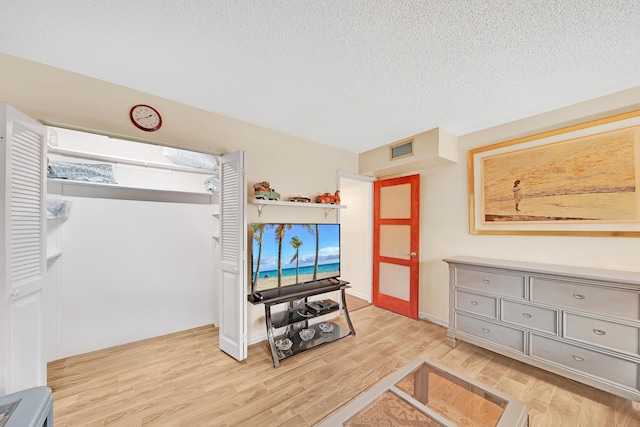 living room with light hardwood / wood-style floors and a textured ceiling