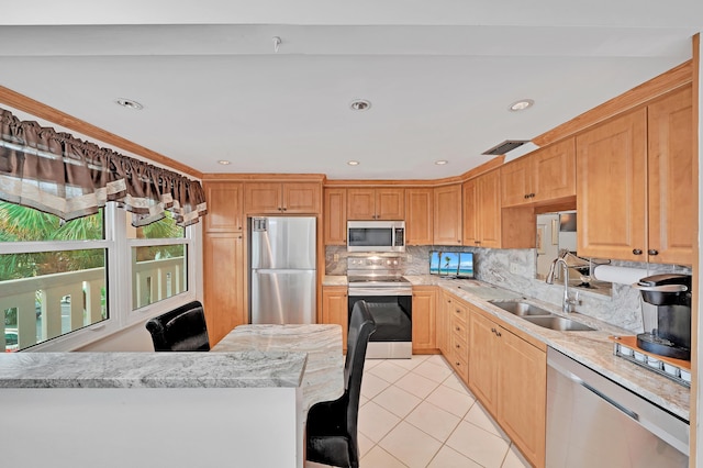 kitchen with backsplash, stainless steel appliances, sink, a breakfast bar area, and light tile patterned flooring