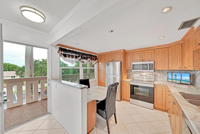 kitchen with backsplash, light tile patterned floors, a textured ceiling, ornamental molding, and appliances with stainless steel finishes