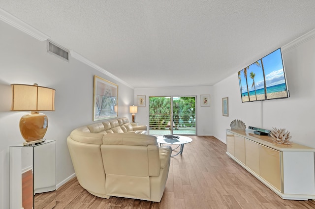 living room with a textured ceiling, light wood-type flooring, and ornamental molding