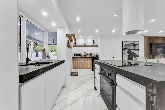 kitchen featuring dark stone counters, white cabinets, black appliances, sink, and ceiling fan