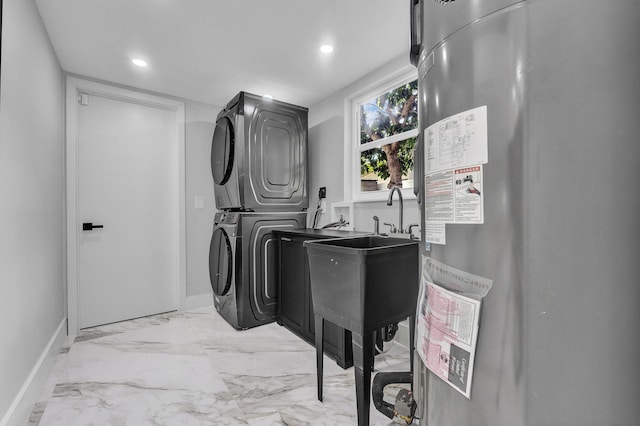 clothes washing area featuring stacked washing maching and dryer and water heater