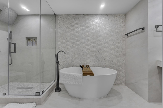 bathroom with separate shower and tub and tile walls