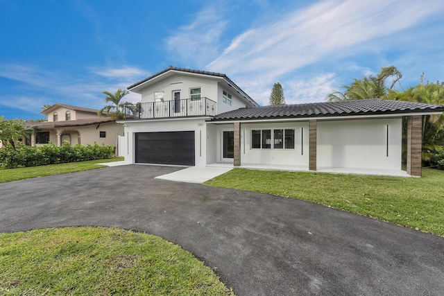 view of front of home featuring a balcony, a front lawn, and a garage