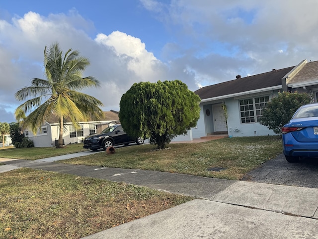 single story home featuring a front lawn