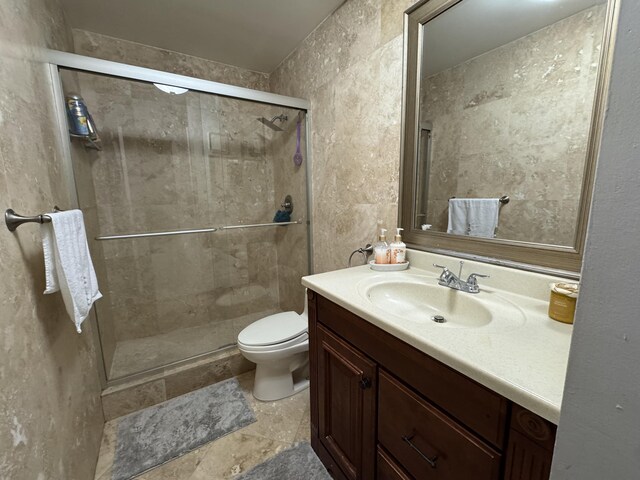 bathroom featuring vanity, toilet, and a shower with door