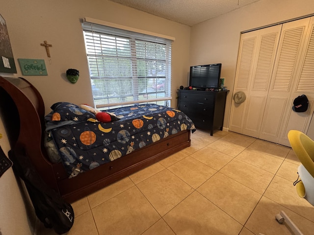 tiled bedroom featuring a closet and a textured ceiling