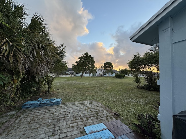 yard at dusk featuring a patio