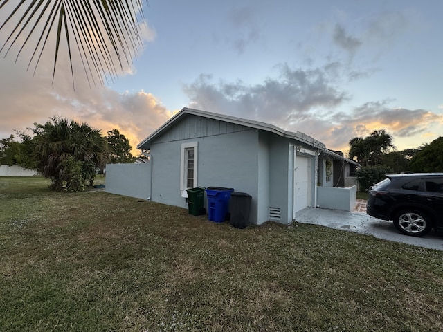 property exterior at dusk featuring a yard