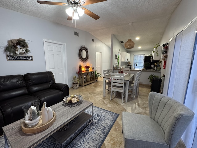 living room with a textured ceiling, ceiling fan, and lofted ceiling