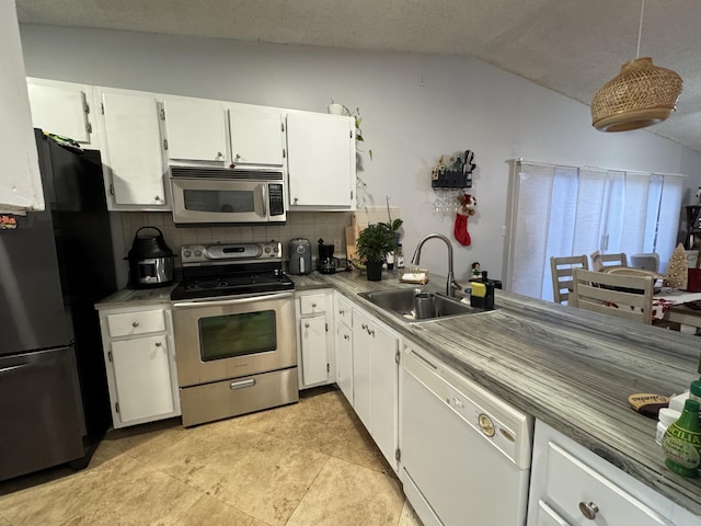 kitchen with a textured ceiling, stainless steel appliances, white cabinetry, and sink