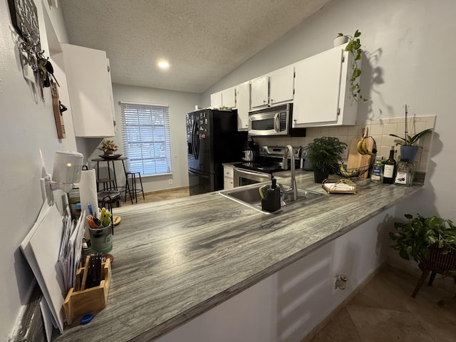 kitchen with white cabinets, sink, a textured ceiling, appliances with stainless steel finishes, and tasteful backsplash