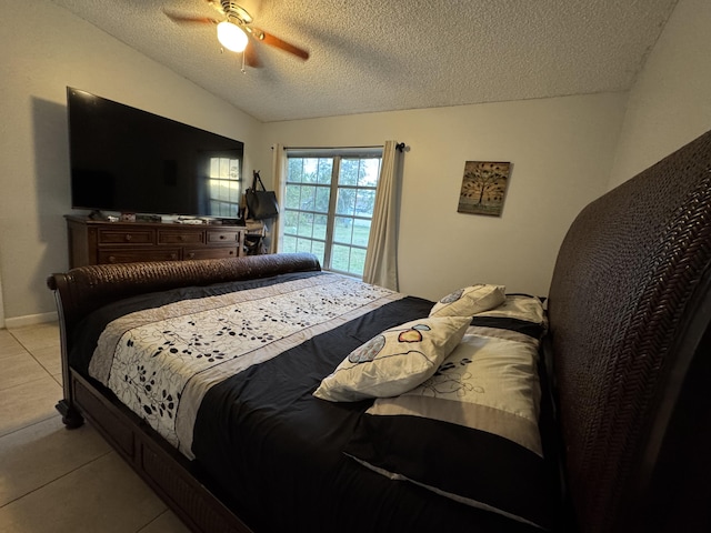 bedroom featuring ceiling fan, light tile patterned flooring, and a textured ceiling