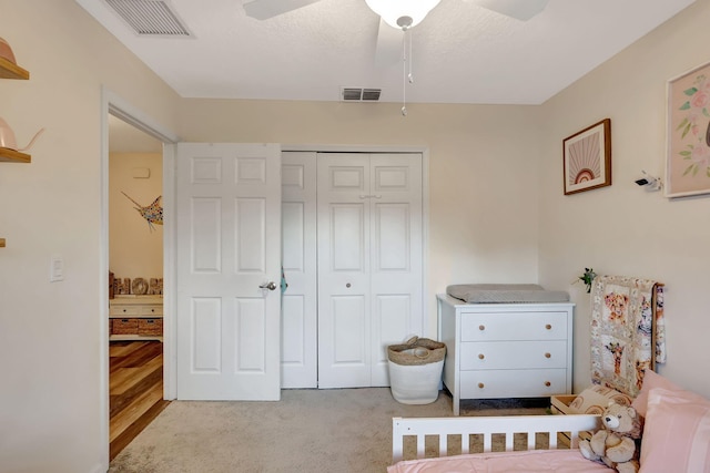 carpeted bedroom with ceiling fan and a closet