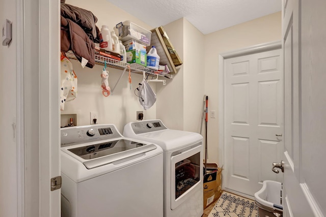 laundry area with a textured ceiling and washing machine and dryer