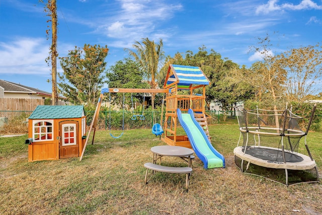 view of jungle gym featuring a lawn and a trampoline