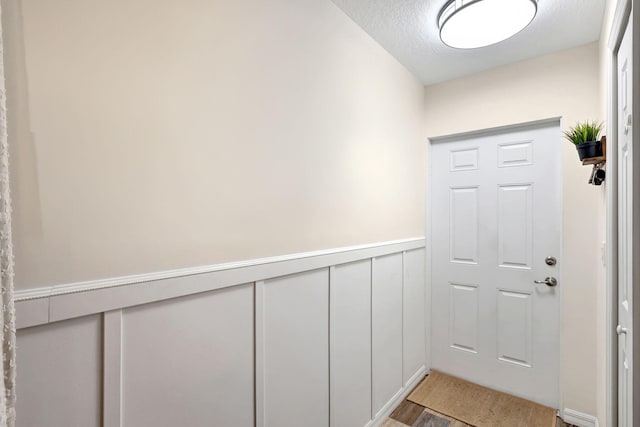 doorway to outside with hardwood / wood-style floors and a textured ceiling