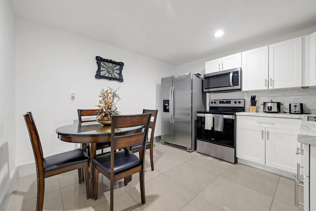 2365 NW 68th St, Miami, FL 33147 - kitchen with appliances with stainless steel finishes, light countertops, decorative backsplash, white cabinets, and recessed lighting