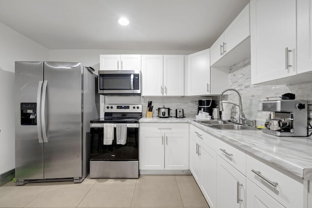 2365 NW 68th St, Miami, FL 33147 - kitchen featuring appliances with stainless steel finishes, a sink, white cabinets, and light tile patterned flooring