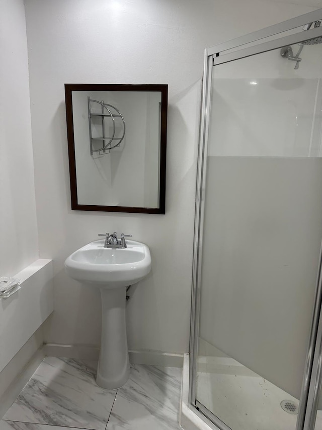 2365 NW 68th St, Miami, FL 33147 - bathroom with a stall shower, baseboards, marble look tiles, and a sink