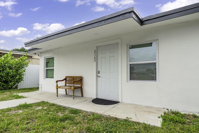 2365 NW 68th St, Miami, FL 33147 - view of exterior entry featuring stucco siding and fence