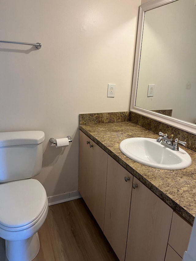 bathroom featuring vanity, hardwood / wood-style flooring, and toilet