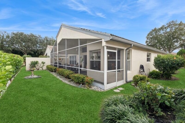 back of house with a yard and a sunroom