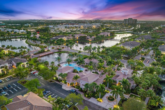 aerial view at dusk featuring a water view