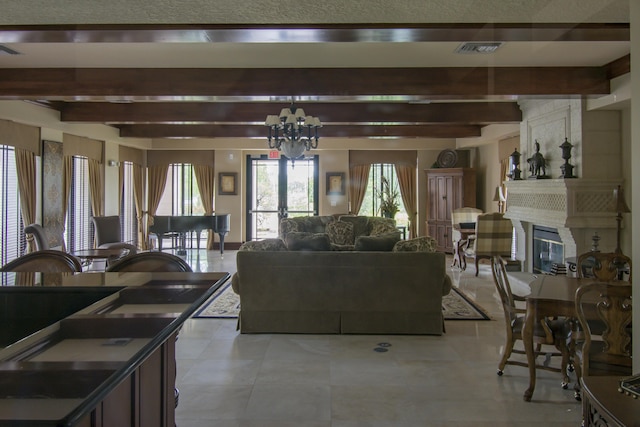 living room featuring a fireplace, beam ceiling, an inviting chandelier, and french doors