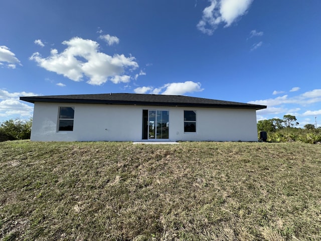 rear view of property featuring a lawn