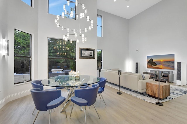 dining area featuring hardwood / wood-style floors and a towering ceiling