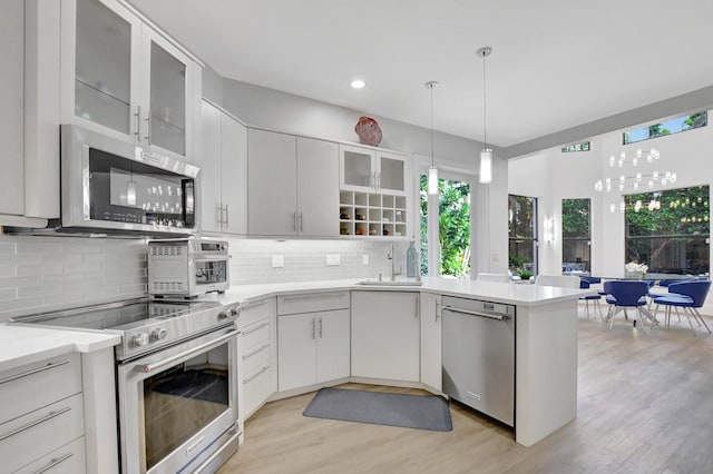 kitchen with stainless steel appliances, white cabinetry, a wealth of natural light, and sink