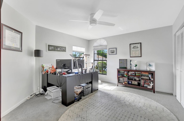 carpeted home office featuring ceiling fan