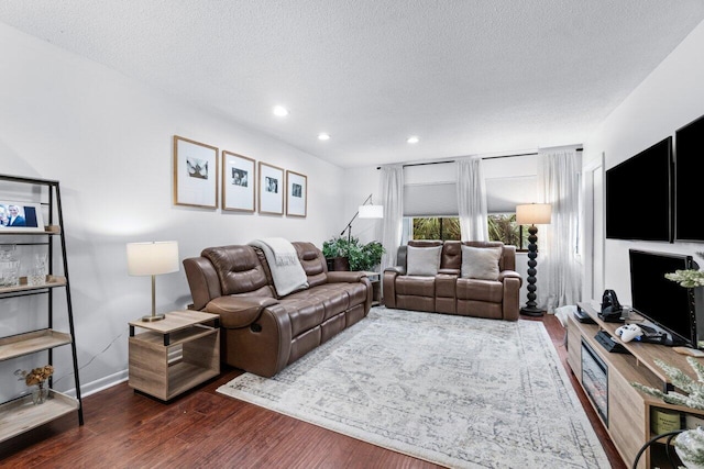 living room featuring a textured ceiling and dark hardwood / wood-style floors