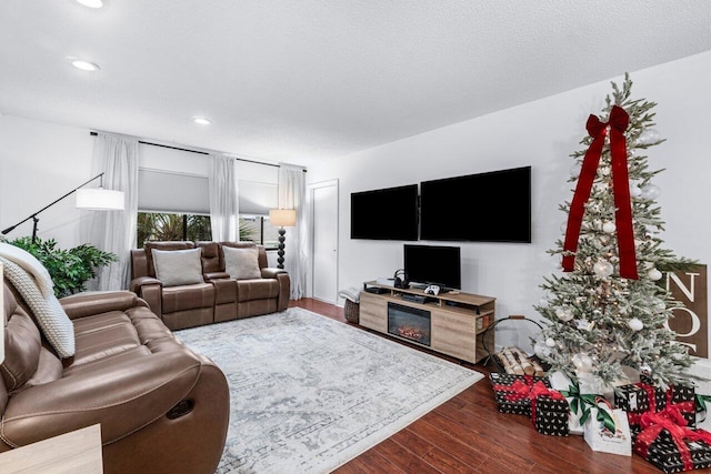 living room with a textured ceiling, dark hardwood / wood-style floors, and a fireplace