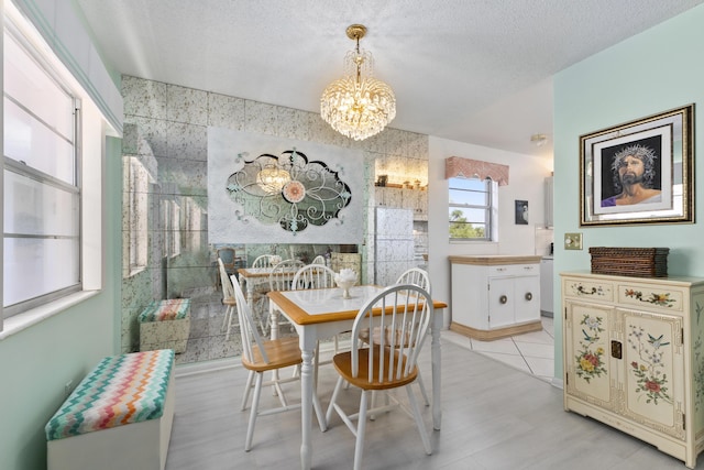 dining area with a textured ceiling and an inviting chandelier