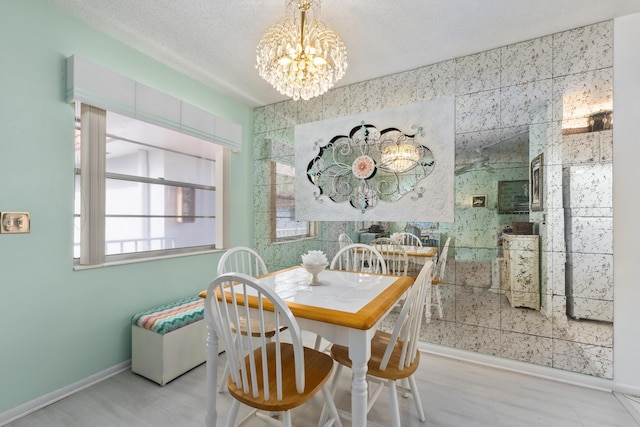 dining area with a textured ceiling and an inviting chandelier