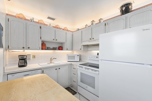 kitchen with backsplash, sink, and white appliances