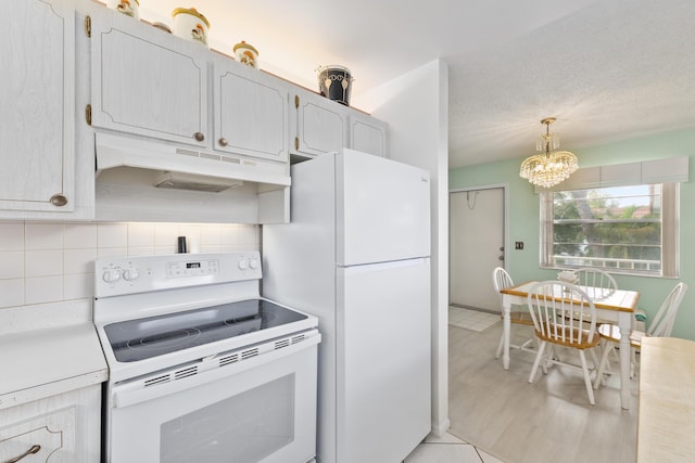 kitchen with decorative backsplash, hanging light fixtures, white appliances, and a notable chandelier