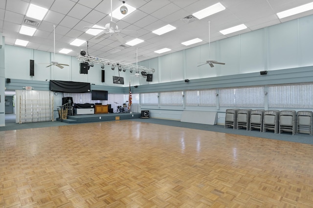 misc room featuring ceiling fan, a towering ceiling, and light parquet floors