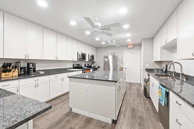 kitchen featuring white cabinets, a center island, sink, and appliances with stainless steel finishes